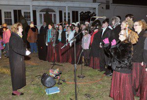 Westfield High School Music Director Korey Bruno, left, directs the Westfield High School Concert Choir during a past tree lighting ceremony in Westfield. (WNG File Photo)