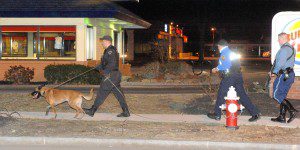 A Massachusetts State Police trooper, right, carries a shotgun as a State Police K-9 officer uses a specially trained dog to track the scent of the gunman who shot and robbed a man near Westfield Auto Parts near Mechanic Street in Westfield last night. The suspect was reported to be about 5 foot 11 inches, Hispanic, and dressed in all black. The shooting was reported at 9:20 p.m. (Photo by chief photographer Frederick Gore)