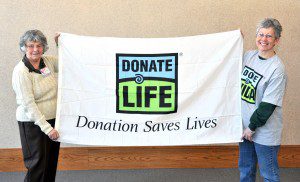 Susan Sanders, right, of Southwick, holds a Donate Life flag with her mom Eleanor Bates at the Southwick Town Hall. Sanders received a heart transplant in 2008. (File photo by chief photographer Frederick Gore).