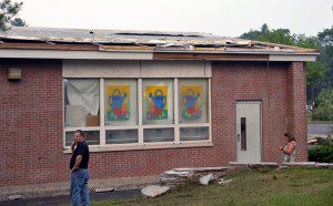 Residents examine the damage to the membrane of Munger Hill Elementary School following the June 1, 2011 tornado which ripped a 2,800-square-foot section off the building over the kindergarten wing. (File photo by Frederick Gore)