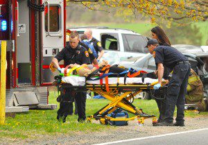 Southwick emergency medical technicians prepare to transport one of the two drivers involved in a motor vehicle accident near Meadow View Farm on College Highway, Monday. (Photo by Frederick Gore)