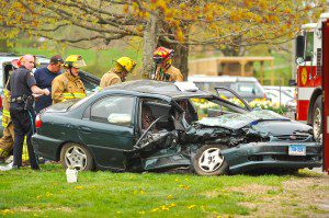 Southwick emergency responders examine the wreckage of a two-car accident near 120 College Highway, Monday. (Photo by Frederick Gore)