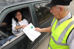 Sal Vella, right, an employee of the City of Westfield, inspects the 2013 green and white transfer station sticker of Linda Tremblay as she enters the Twiss Street transfer station yesterday. (Photo by Frederick Gore)