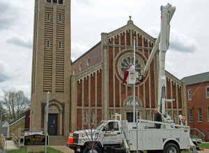 Mike Sobczyk, owner of the Sign Shop in Westfield, donated his time and materials to help double coat the two flag poles located in front of Holy Trinity Church. The Church has a full slate events to be held this year.  (Photo by Don Wielgus)