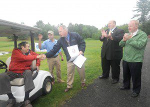 Westfield Mayor Daniel M. Knapik congratulates Ted Perez and his son, Ted Perez Jr., after reading a proclamation honoring the Perez family for their achievement of creating East Mountain Country Club and operating it for 50 years. Applauding are State Sen. Michael R. Knapik and State Rep. Don Humason.The Perez family celebrated the anniversary by offering "throwback pricing" at the original cost for the course, $2 for a round or $1 for nine holes. (Photo by Carl E. Hartdegen)