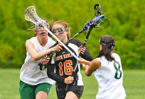 St. Mary midfielders Aisling Smith, left, and Miranda Arena, right, attempt to double block South Hadley's Gabe Dulude, center, during Wednesday's game at Stanley Park. South Hadley went on to win 16-6. (Photo by Frederick Gore)