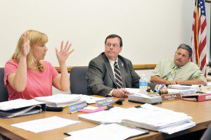 Southwick selectwoman Tracy L. Cesan, left, expresses her displeasure of remaining a secretary/clerk during last night's meeting at the Southwick Town Hall. Selectman Russ Fox, center, will assume the role of chairman and newly elected Joe Deedy, right, will assume the vice-chairman position of the board. (Photo by Frederick Gore)