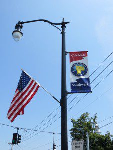 Flags and banners adorn half of the town's new light fixtures along College Highway thanks to the efforts of two volunteers. (Photo by Hope E. Tremblay)