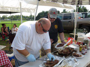Stan Choiniere and Andy Cleveland of team 2nd Hand Smoke slice ribs for the judges in 2013. (File photo by Hope E. Tremblay)