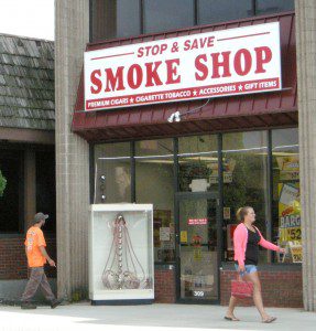 A passerby pauses to examine a large hookah displayed outside the Stop & Save Smoke Shop on East Main Street. (Photo by Carl E. Hartdegen) 