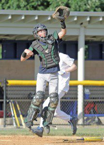 A catcher leaps for the ball as a base runner scores during a practice at Westfield State University last night. (Photo by Frederick Gore)