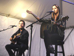 Cassadee Pope, the headliner for last night’s free MusicFest 2013 concert at Park Square, speaks to the audience as she starts her set. Pope was backed by Steve Fekete, left,  and (not seen) Jim McGorman. (Photo by Carl E. Hartdegen) 