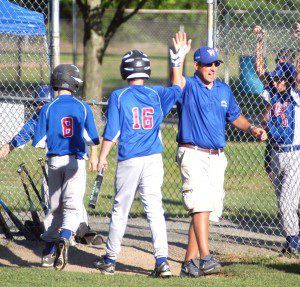 Westfield Little League Baseball South All-Stars manager Mike Raposo congratulates his players during a tournament game this summer. Play will extend into the fall this year for the first time. (Westfield News file photo)