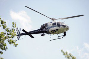  A Massachusetts State Police helicopter checks the area in back of the Westfield Shops where an armed man was last known to be after he robbed a Rite-Aid store at gunpoint Friday. (Photo by Frederick Gore)