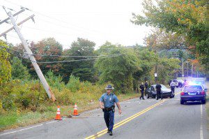 An State Trooper walks through the scene of one car crash on Shaker Road this morning which may have claimed the life of the operator when the vehicle crashed into a utility pole during a high-speed chase. (Photo by Carl E. Hartdegen)