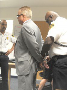 A probation imposed a year ago when a charge of operating under the influence of drugs was adjudicated. (Photo by Carl E. Hartdegen court officer emplaces handcuffs on former Blandford selectman Robert R. Nichols when he was taken into custody Thursday in Westfield District Court after he was found to have violated)