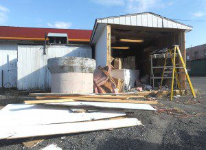 Damaged parts of a shed attached to the back of the Getty Mart gas station and convenience store on Elm Street are stacked on the side while repairs are underway after the shed was repeatedly struck, apparently intentionally, by a motorist who was subsequently arrested. (Photo by Carl E. Hartdegen) 