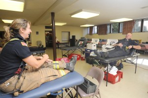  Fire Capt. Rebecca Boutin jokes with Police Officer Kerry Paton as they wait to donate blood Saturday morning at a Guns and Hoses ‘Blood Wars’ competition waged between their departments to collect blood for the American Red Cross. (Photo by Carl E. Hartdegen) 