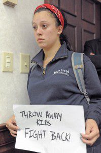 A Westfield State University student holds a sign during a Board of Trustee meeting at the university Wednesday. (Photo by Frederick Gore)