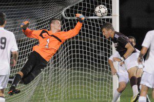 Westfield goal keeper Robert Bernadara, left, leaps for the save from the header of Amherst defender Adrian Haughton. (Photo by Frederick Gore)