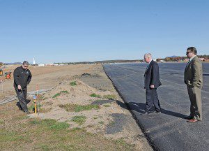 Brian Barnes, manager of Barnes Regional Airport in Westfield, left, checks one of the runway lights along the new $15.6 million 9,000-foot runway with Westfield Mayor Daniel Knapik, center, and City Advancement Officer Jeffrey Daley during a tour Tuesday. (Photo by Frederick Gore)
