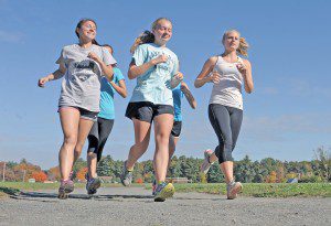 Members of the Southwick Cross Country team warm up on the gravel athletic track located at Powder Mill Middle School Tuesday. (Photo by Frederick Gore)