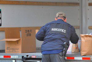 A narcotics agent checks a box as state and federal law enforcement agents seized property from an apartment located at 5/7 Fairview Street in Westfield yesterday afternoon. (Photo by Frederick Gore)