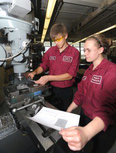 Westfield Vocational-Technical High School sophomore Mira Mayboroda checks the blueprint as she and classmate Vitiliy Tereshchuk work on a project to make identifying tags for the keys rings for the police department's fleet of vehicles. (Photo by Carl E. Hartdegen)