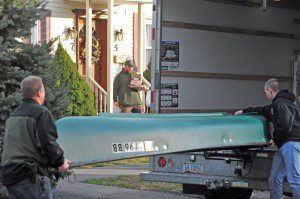 Federal and state law enforcement officers load a canoe into a waiting U-Haul truck as other agents, background, remove items from an apartment located at 5/7 Fairview Street in Westfield yesterday. Agents and troopers were on scene after executing a court order to seize property at that location. (Photo by Frederick Gore)