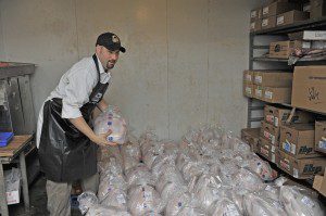 Dan Puza Jr., an employee at the North Elm Butcher Block in Westfield, searches through a batch of fresh turkeys for a customer, who requested a specific weight. (Photo by Frederick Gore)