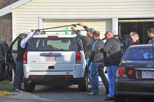 State police troopers and federal agents remove a roof rack from a vehicle in the driveway located at 5/7 Fairview Street in Westfield yesterday afternoon. Items from the vehicle were tagged as "evidence" and removed to a waiting U-Haul truck driven by federal agents. Also on scene were FBI agents, U.S. postal agents, state police troopers, narcotic agents and FBI photographers. (Photo by Frederick Gore)