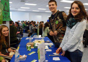 Be Green member Jenna Margarites, left, collects recycling pledges from junior Casey Pease and senior Jessica Lashtur, organizer of the recycling challenge between the classes. (Photo submitted) 