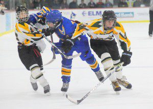 St. Mary sophomore forward Johnathan Spear, left, tangles with Chicopee Comp's Jeremy Lewis, center, as St. Mary's Jake Neilsen, right, chases a loose puck during the second period of last night's season opener. St. Mary went on to win 7-6 at the Amelia Park Ice Arena. (Photo by Frederick Gore)