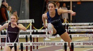 Sophomore Meg McNamara soars over the hurdle on her way to a first place finish. (Photo by Mickey Curtis)