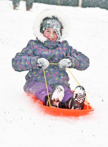 Madeline McGregor, 7, of Feeding Hills, enjoys her day off from school while sliding at the Southwick-Tolland-Granville High School with her dad Thursday. (Photo by Frederick Gore)