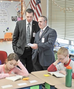 State Rep. Nicholas Boldyga, left, and Massachusetts Secretary of Education Matthew H. Malone, stand in the back of a sixth-grade classroom at Powder Mill Middle School as students concentrate on a reading assignment yesterday. Malone toured the Southwick-Granville-Tolland Regional school district as part of an ongoing hands-on educational tour of the state. (Photo by Frederick Gore)