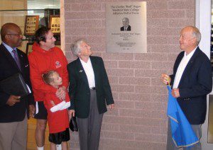Charles "Bud" Hagan, right, unveils a plaque in his honor as Westfield State dedicated its new Athletics Hall of Fame area in the Woodward Center front lobby during the 2006 Alumni Weekend. Also pictured, left to right, are: Dr. Arthur Jackson, former Westfield State vice president of student affairs, and three members of Bud Hagan's family: son Jim, granddaughter Mairead, and wife Kathy.
