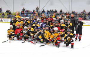A group of children pose for a photo during last year's fundraiser game between the Westfield Fire Department and former Boston Bruins players at the Amelia Park Ice Arena. (File photo by Frederick Gore)