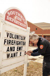 Southwick Fire Inspector Ralph Vecchio places a "Help Wanted" sign in front of the Southwick Fire Department . (File photo by Frederick Gore)