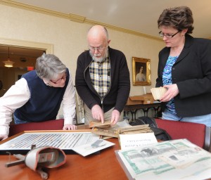 Bob Brown shows some of the items in the collection of 'ephemera' he donated to the Westfield Athenaeum to the archivist of the institution, Kate Deviny, and the athenaeum's interim director, Cher Collins. (Photo by Carl E. Hartdegen)