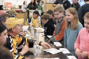 Former Boston Bruins players, left, sign autographs during last year's fundraiser at the Amelia Park Ice Arena. (Photo by Frederick Gore)