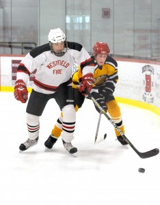 Westfield Fire Department's Chris King, left, battles Black & Gold Legends' Quintin Brickley. The annual charity hockey event was recently renewed. (File Photo)