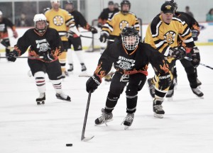 Craig Shacker, foreground, of the Westfield Firefighters team, moves the puck during the 2014 fundraiser with former members of the Boston Bruins at the Amelia Park Ice Arena. (Photo by Frederick Gore)