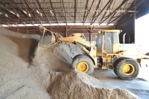 A Southwick Department of Public Works employee mixes a salt/sand mixture at the former DPW yard. (File photo by Frederick Gore)