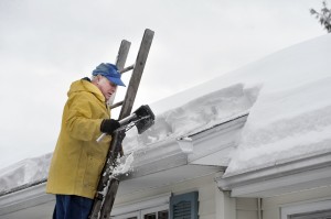 Hilmar Hoppe of Westfield cleans his roof and gutters to prevent ice dams which can damage the inside and outside of the home. (Photo by Frederick Gore)