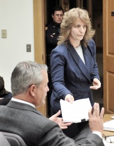A Southwick police officer, rear, watches Southwick Town Clerk Michelle L. Hill, pass a set of documents to Southwick town attorney Kenneth J. Albano, of the law firm Bacon & Wilson, during last night's selectman's meeting after a complaint was filed against Selectwoman Tracy L. Cesan. Hill filed the complaint Jan. 27 and accused Cesan of being unprofessional with regard to a Freedom of Information request from a citizen. (Photo by Frederick Gore)