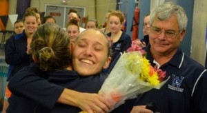 Emily Fullerton flashes a big smile after receiving a hug and flowers from Katie Sterpka during Senior Day.