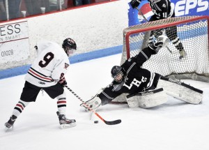 Longmeadow senior goal tender Omar Natour, right, deflects the shot of Westfield junior forward Connor Sullivan, left, during the first period of Saturday's game at the Olympia Ice Arena. (Photo by Frederick Gore)