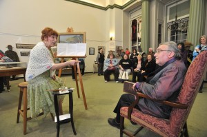 Carol and Rock Palmer of Westfield portray the parts of Florence Rand Lang and Henry Lang as they perform a skit Saturday evening at the Westfield Athenaeum’s 150th celebratory open house. The skit portrayed the couple’s presumed conversation as they discussed the request for a $50,000 contribution to the Athenaeum which ultimately funded the Jasper Rand Art Gallery and the Lang Auditorium. (Photo ©2014 Carl E. Hartdegen)   
