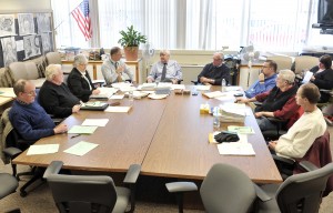 Southwick School Business Manager Stephen Presnal, rear left, and John D. Barry, rear center, discuss a document during last night's school committee meeting in Southwick. (Photo by Frederick Gore)